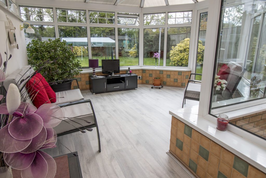 A bright conservatory with underfloor heating laid under laminate flooring