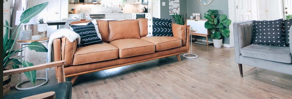 a chic living room with a brown leather sofa and a grey boutique chair
